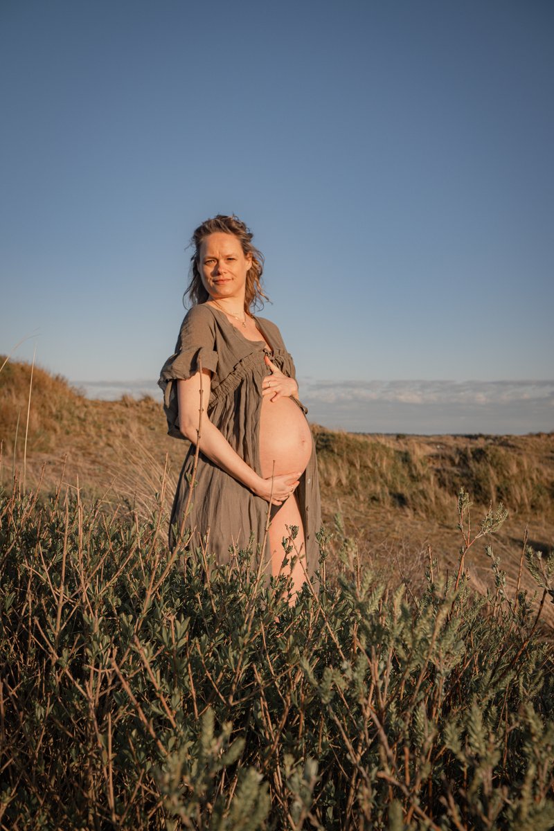 Detail van handen rond een ronde zwangere buik