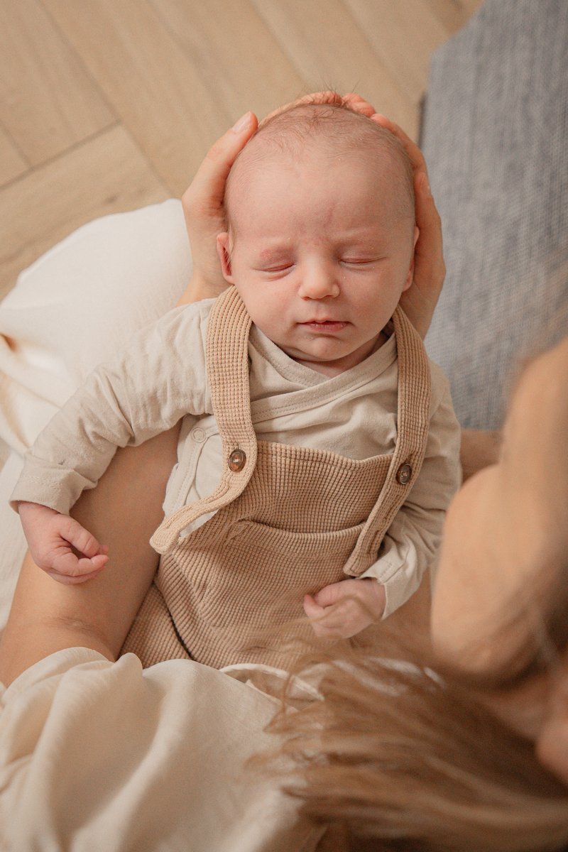 Slapende newborn in warme natuurlijke tinten