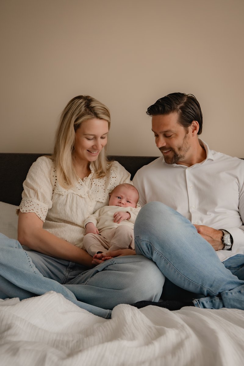 Ouders op bed met hun newborn, rustig moment