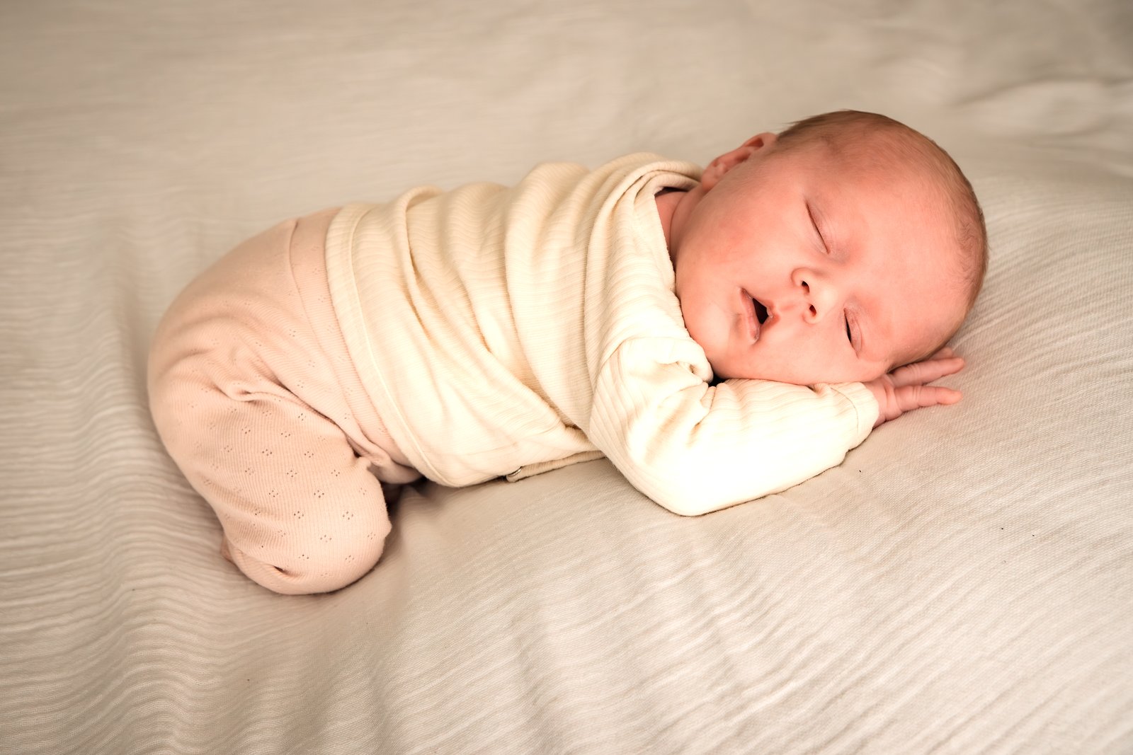 Slapende newborn op een zachte deken, warm ingebakerd